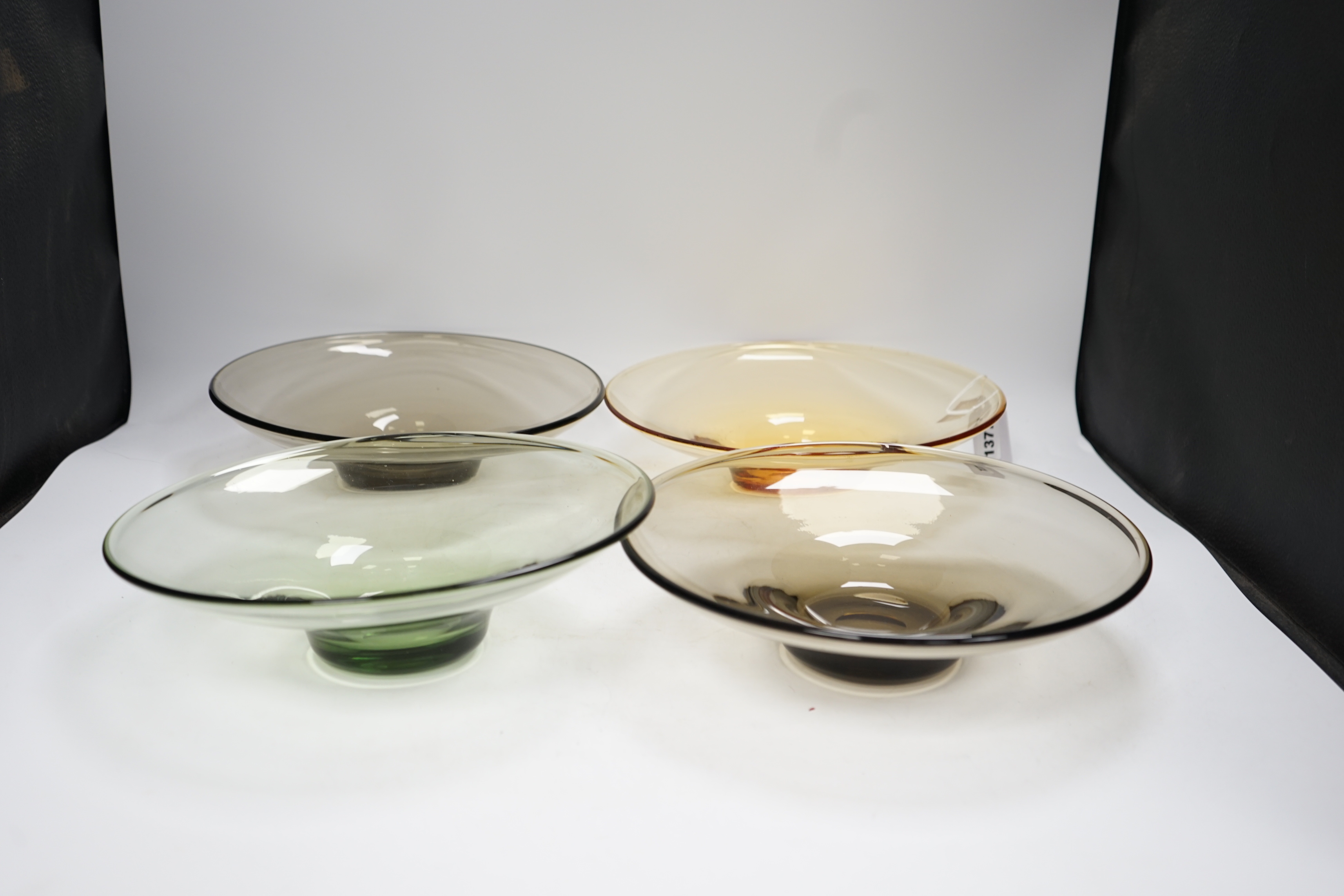 Four colour tinted glass dishes, largest 28cm diameter